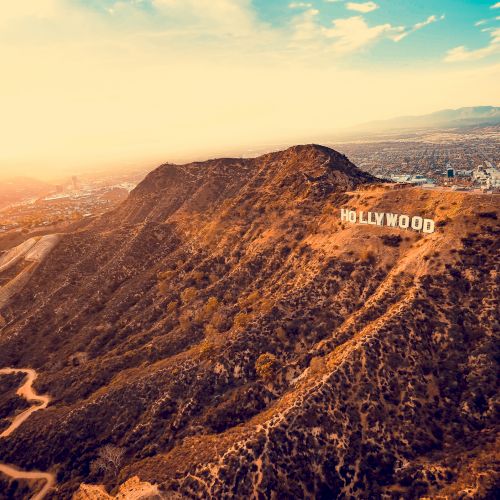 This image features an aerial view of the Hollywood Hills with the iconic 