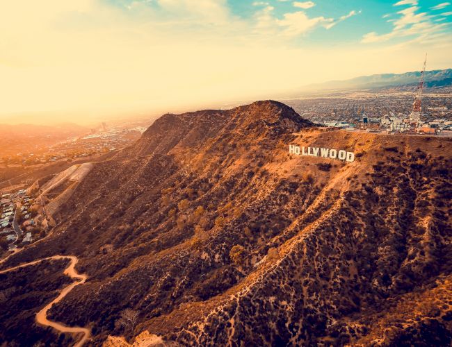 This image features an aerial view of the Hollywood Hills with the iconic 